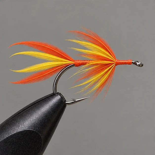 A mixed yellow and orange hackle collar surrounds the feather tail base.