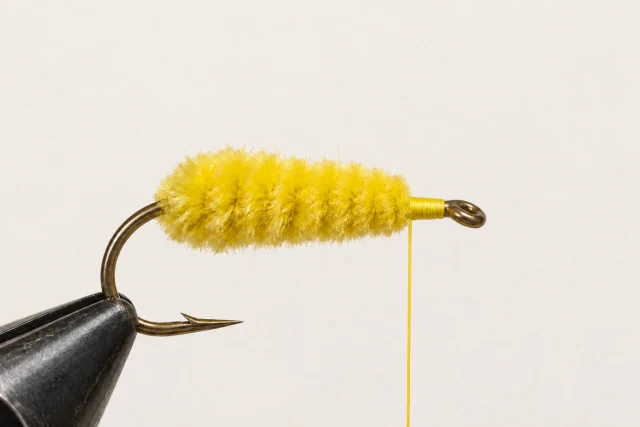 A yellow chenille body covers the wire; the front tying space and hook eye remain clear.